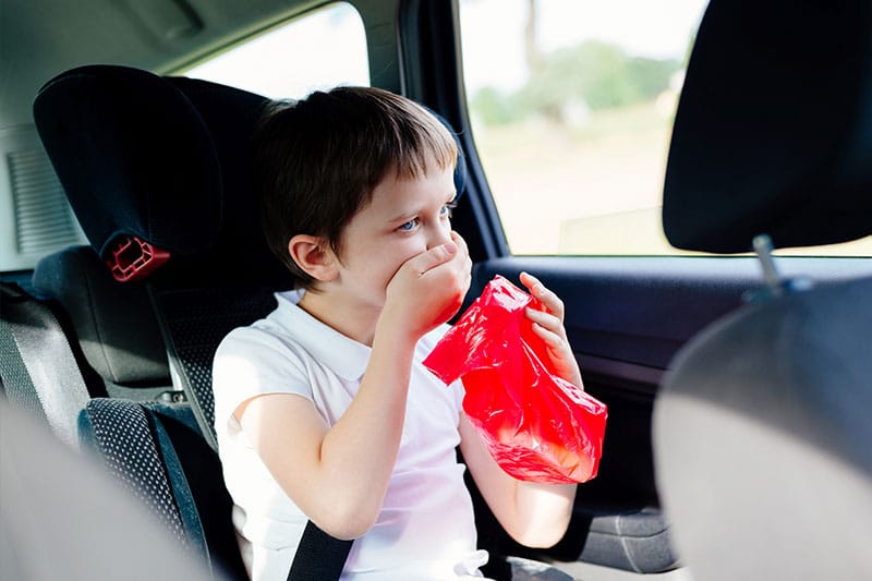 child in a car having motion sickness