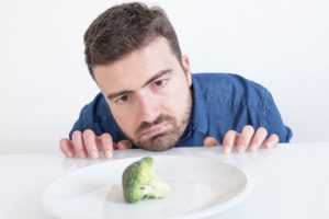 hungry man wanting to eat the broccoli infront of him